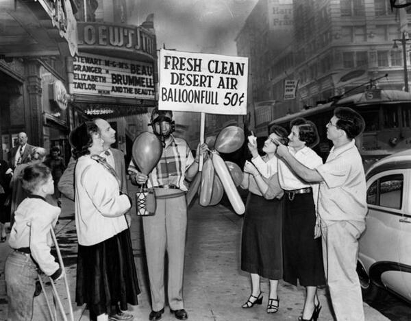 Man selling fresh clean desert air for 50 cents a balloonfull in front of Loew's State Theatre in Los Angeles, Oct. 22, 1954. Herald-Examiner Collection photo courtesy of The Los Angeles Public Library