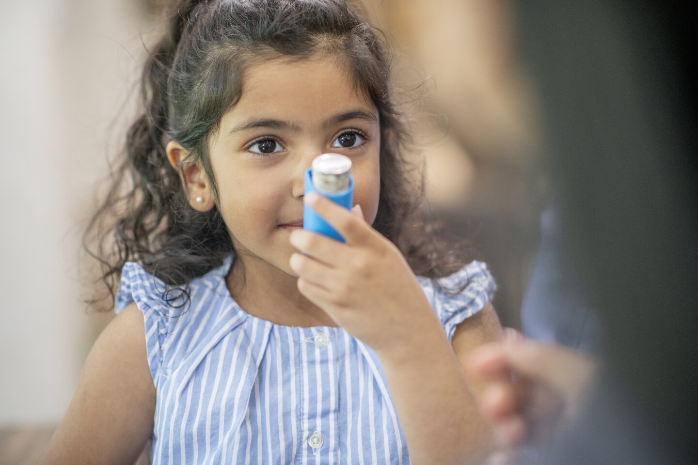 Young girl using an asthma inhaler