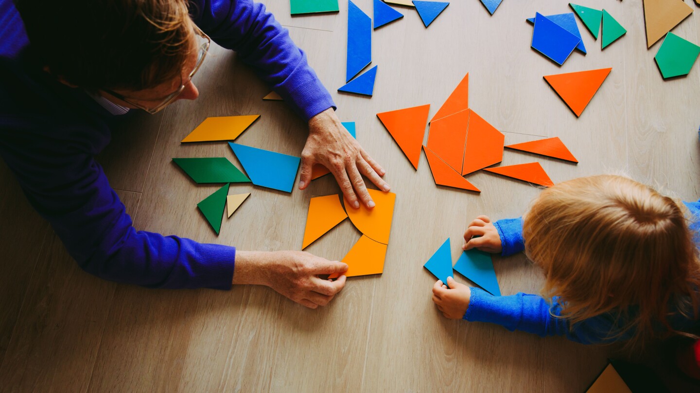 teacher and child playing with geometric shapes