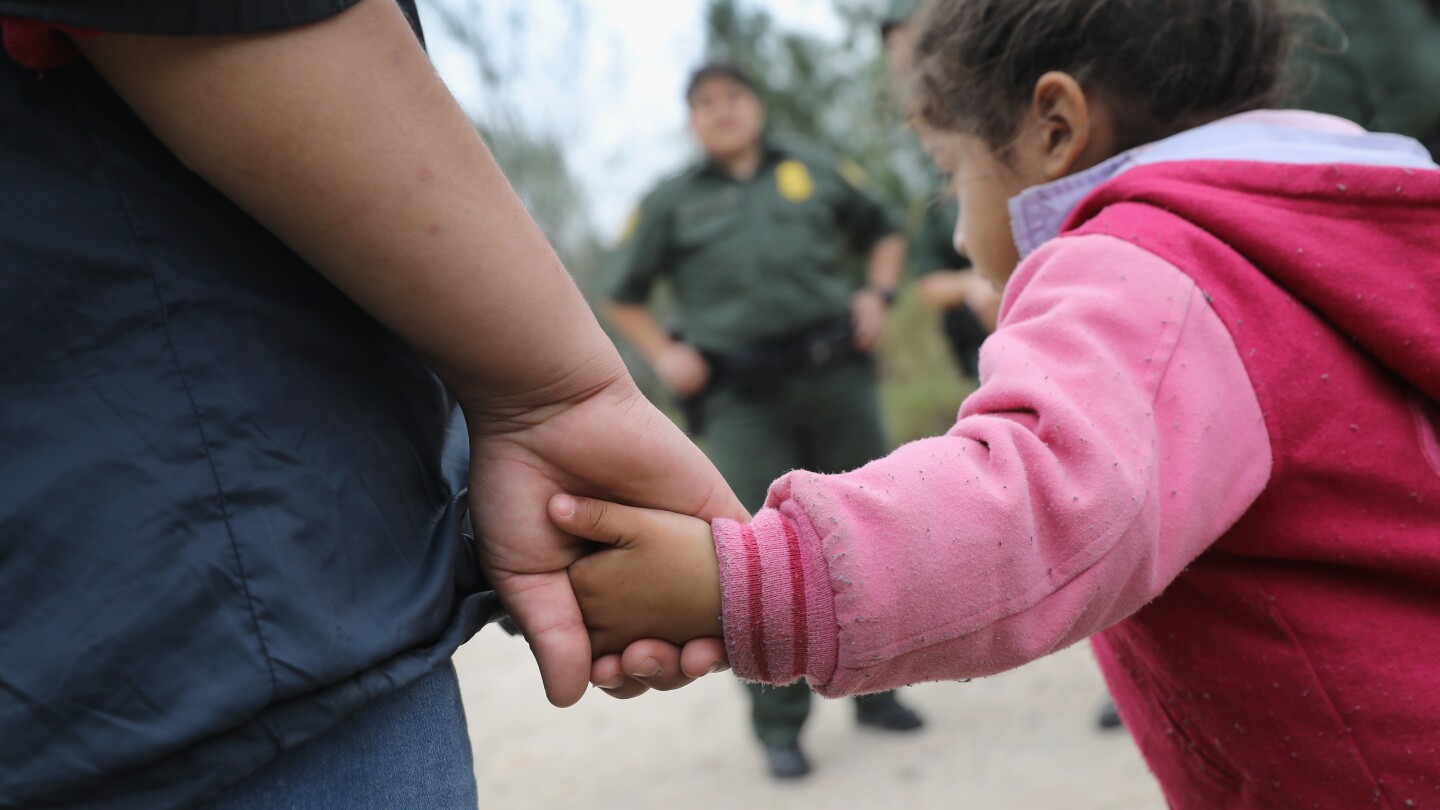 A close-up shot of a little girl holding an adult's hand.