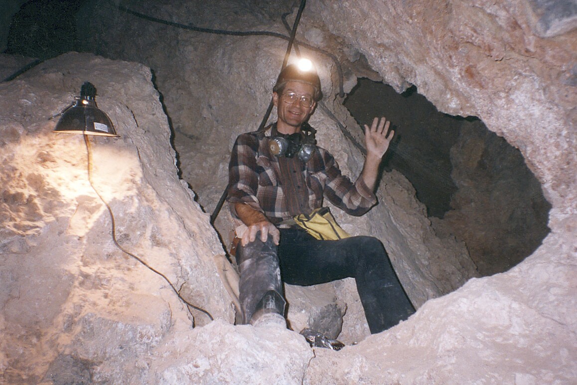 Ralph Lewis photographed at the purported blocked entrance at the bottom of Crystal Cave. About 5 feet above Lewis' head (out of the image frame) is the infamous carbide smoked DORR letters. | Photo: Robert "Bob" Lauten.