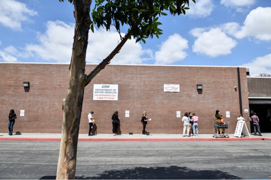 People stand in line while social distancing for the Department of Motor Vehicles.