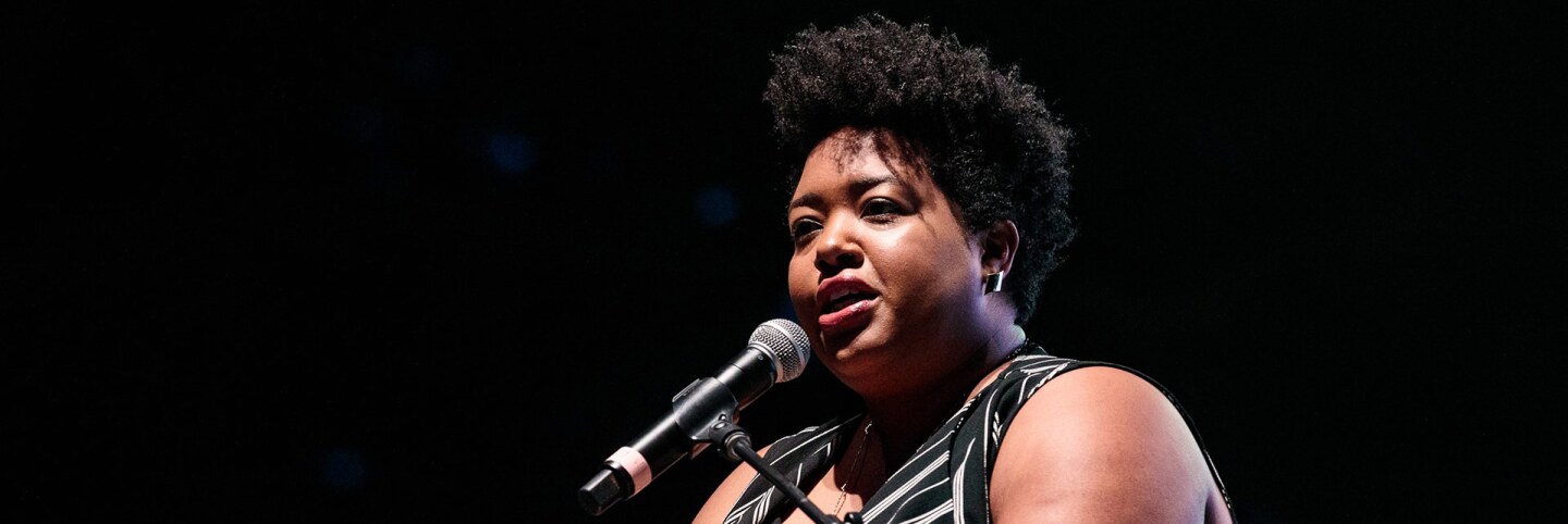 A woman in a black and white dress speaks into a microphone at CAP UCLA's “The People Speak” event. | Courtesy of CAP UCLA